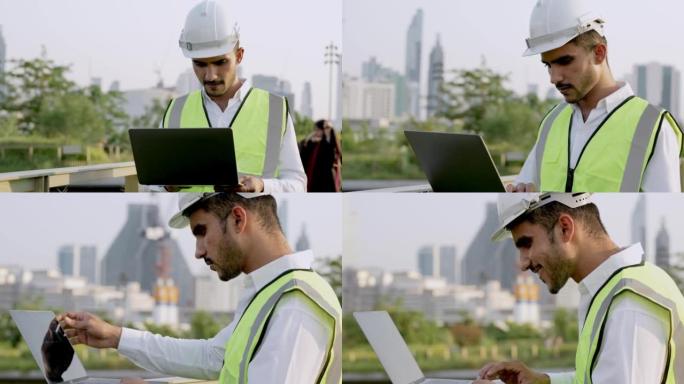工程师印度的工人使用笔记本电脑检查和站立在具有城市和建筑背景的室外空间。