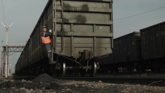 工人坐火车。用煤从货车中形成铁路列车的过程