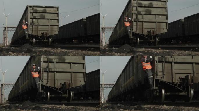 工人坐火车。用煤从货车中形成铁路列车的过程