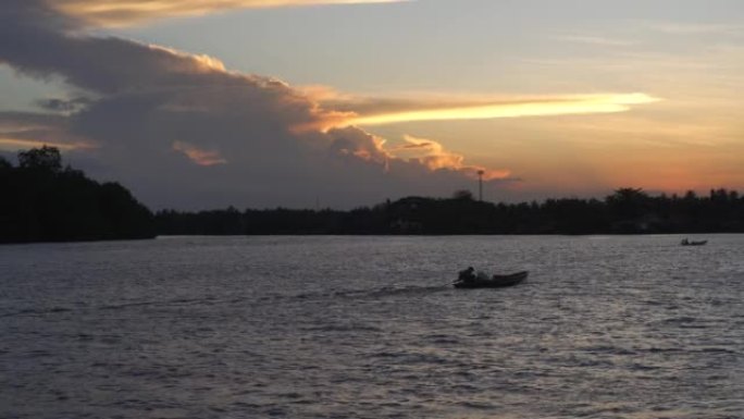湖上的日落景象，平静的水浪表面荡漾，随着渔船的流动而流动。