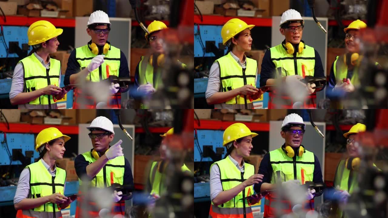 男女工业工厂工程师和技师工人穿着安全背心和安全帽头盔。金属车床工业制造厂。操作员自动化机器人焊接机