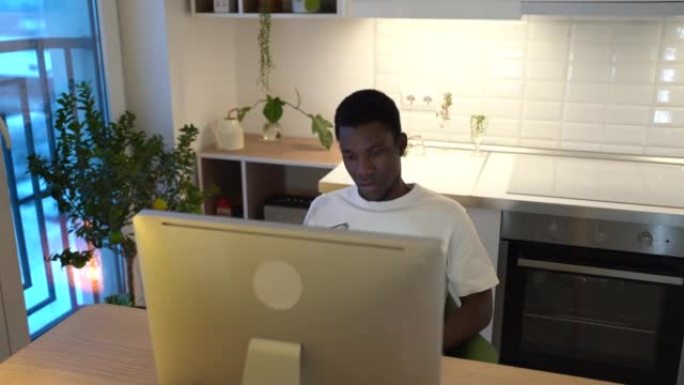 非裔美国人在计算机上工作到深夜后才摘下眼镜擦眼睛