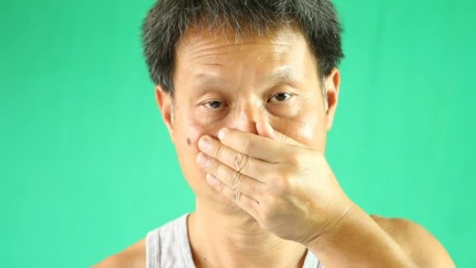 泰国男子以绿色背景关闭鼻子