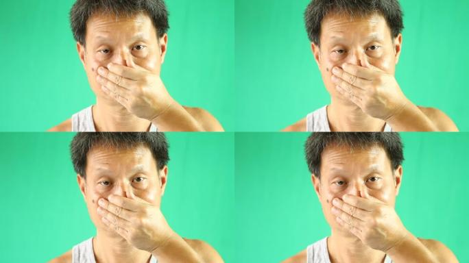 泰国男子以绿色背景关闭鼻子