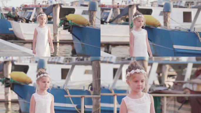 Little girl walks in front of fishing boats