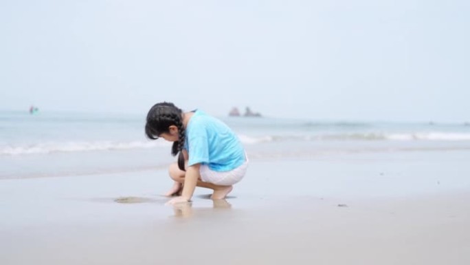 4k亚洲小女孩在夏日晴天在热带海滩上散步和玩耍。
