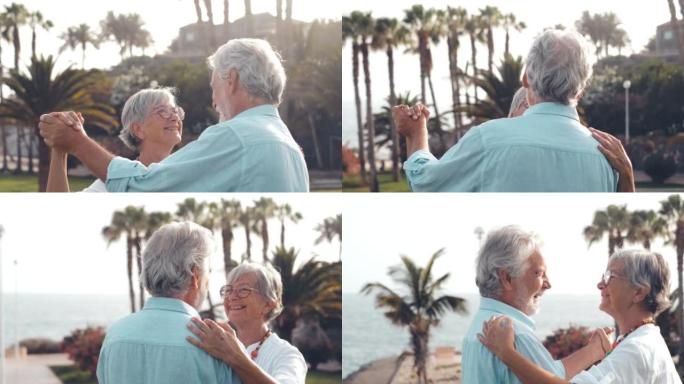 几个老成熟的人一起跳舞，在沙滩上玩得开心，享受和生活的时刻。恋爱中的老年人看起来很开心的肖像。