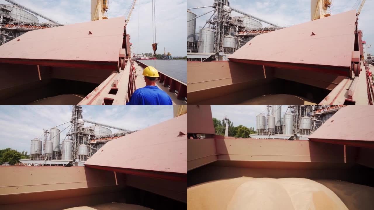 海员在海港谷物码头的bulker船上打开货舱，以装载农作物。农产品运输，世界粮食供应。