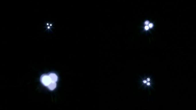 白色UFO光束和光线在黑色背景下移动航天器悬停舞台灯光效果镜头耀斑