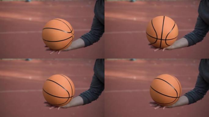 面目全非的年轻人在慢动作的手掌上拿着一个旋转的篮球球