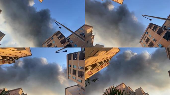 自下而上的照片显示建筑物上方散布有毒烟雾，烟雾排放毒害空气，全球变暖问题导致气候变化。环境污染和野生