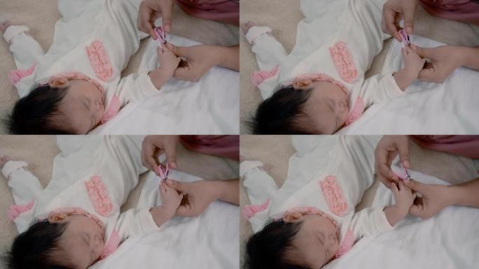 4K，一个女婴睡在棕色的床上，舒服，妈妈抽出宝宝睡觉的时间，带上剪刀给熟睡的宝宝剪指甲，小心翼翼，让