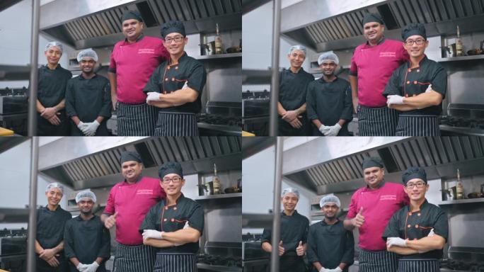 亚洲印度厨师和厨房帮手在商业厨房里看着相机微笑