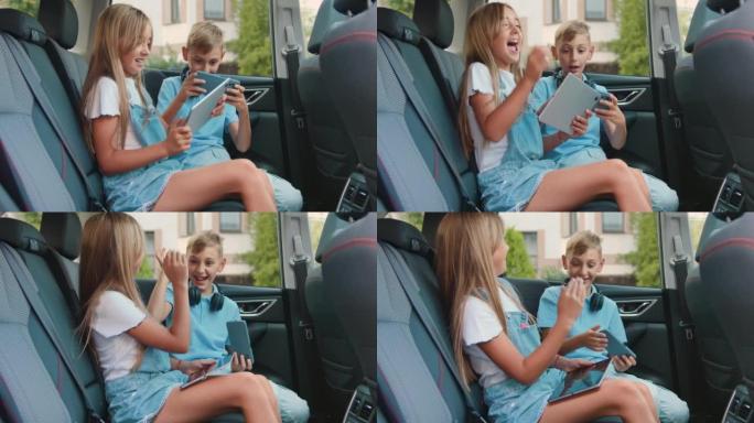 好动的男孩和女孩在车里玩平板电脑和智能手机。儿童使用游戏和娱乐设备，自动旅行