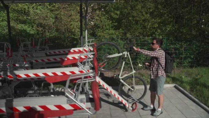 男子将自行车停在德国慕尼黑的两层自行车停车场。双层自行车停车场。骑自行车的人将自行车停在错层自行车停