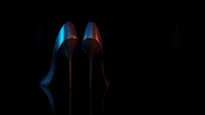 一双女鞋在黑色背景上旋转3D 4k循环动画，带复制空间