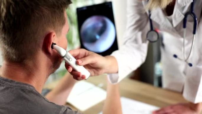 使用数字耳镜的耳鼻喉科医生对患者的耳朵进行医学检查