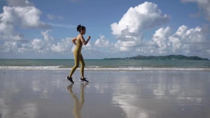 好，强壮，强壮的亚洲女人早上在海滩上锻炼。