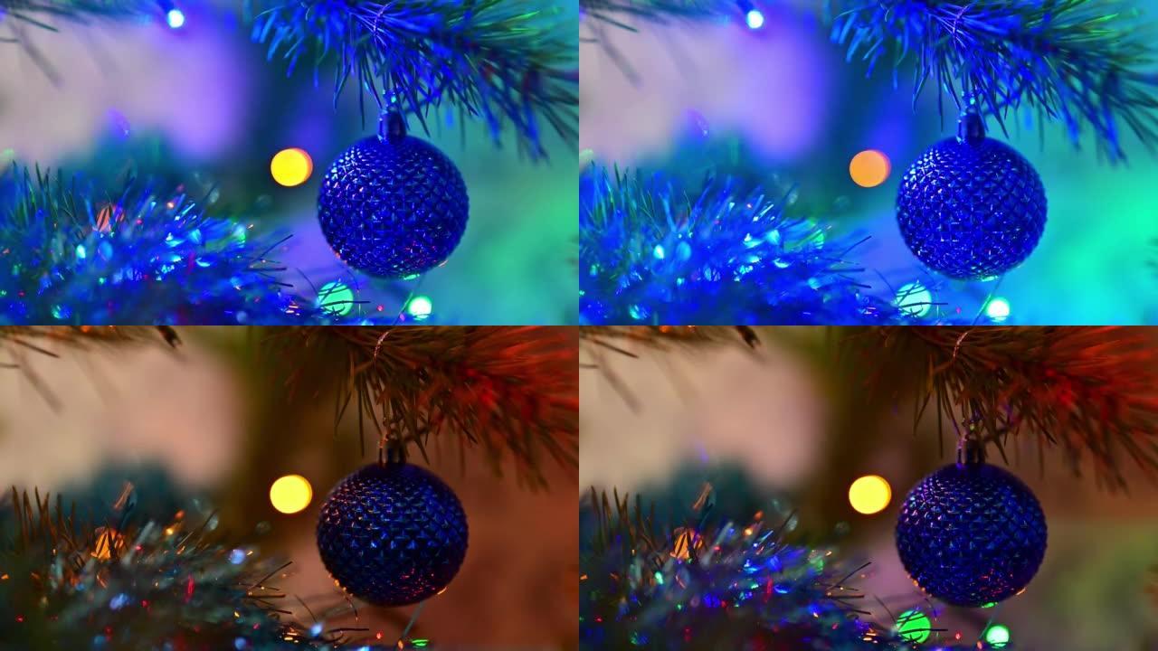 圣诞树上装饰着蓝色玻璃球，在闪烁的灯泡花环背景上的圣诞云杉树枝上。