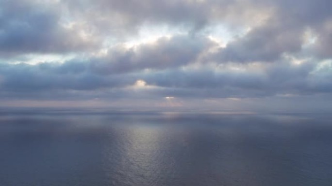 太阳在海上喜怒无常的天空中云中的鸟瞰图。