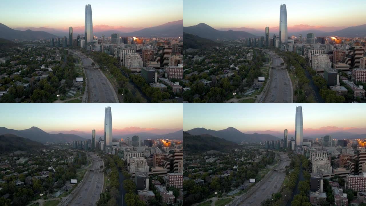 智利圣地亚哥普罗维登西亚蓝色小时背景下的露天免费电影院、马波乔河、桑哈坦摩天大楼和山丘的空中视差