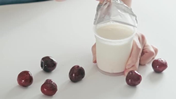 4k视频，打开自制酸奶塑料盖和铝盖。打开塑料罐纯希腊酸奶。商店买了天然酸奶即食。健康休闲食品早餐配新