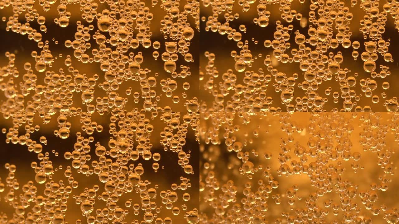 玻璃壁上气泡的宏观视图。玻璃杯、啤酒或香槟泡沫中的泡沫。极其宏观的观点。