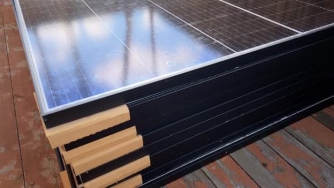 装运并准备安装的高堆光伏太阳能电池板堆叠在旧木地板上。自制