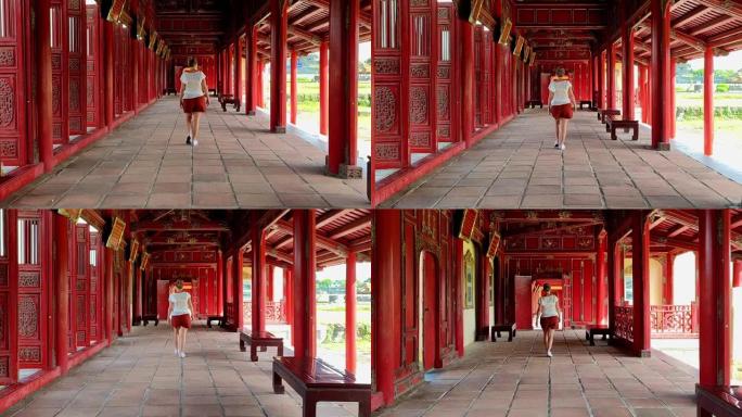 年轻的游客漫步在越南顺化皇城装饰精美的大厅中。