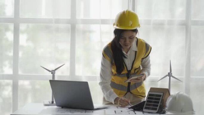 一位亚洲女工程师计划建造一座带有风力涡轮机和太阳能电池板的发电厂，这是一种电力概念。