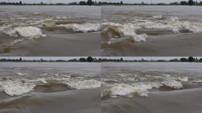 由洪水引起的汹涌的水流形成的汹涌的海浪的全景背景视图。