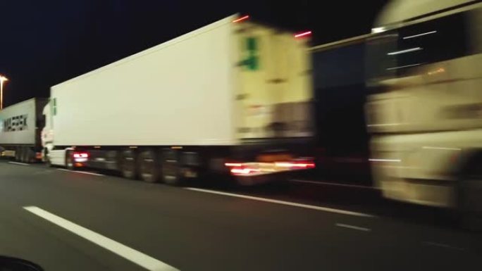 卡车，夜间在高速公路上的货车，运动模糊和灯光痕迹。夜间高速公路上的交通