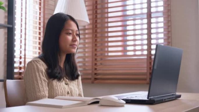 亚洲女孩向在家使用笔记本电脑在线学习的老师问好