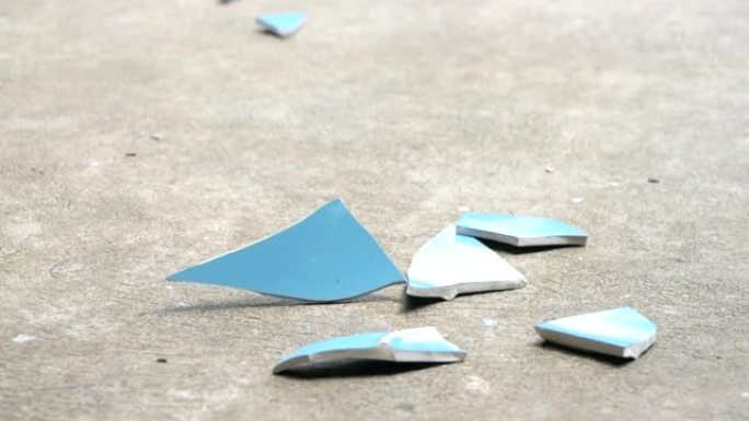 落在水泥地板上的蓝色盘子。