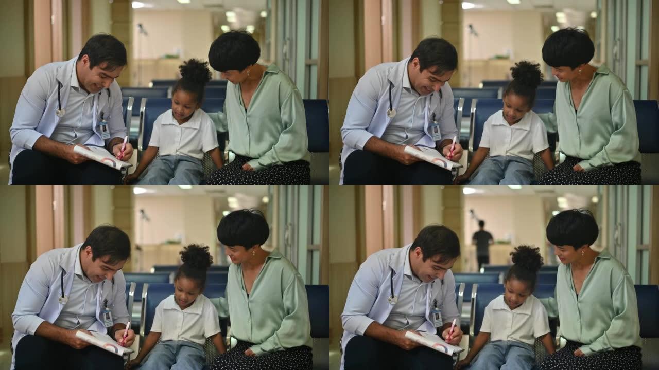 美国男性儿科医生用听诊器听坐在母亲腿上的非洲小女孩的肺和心音