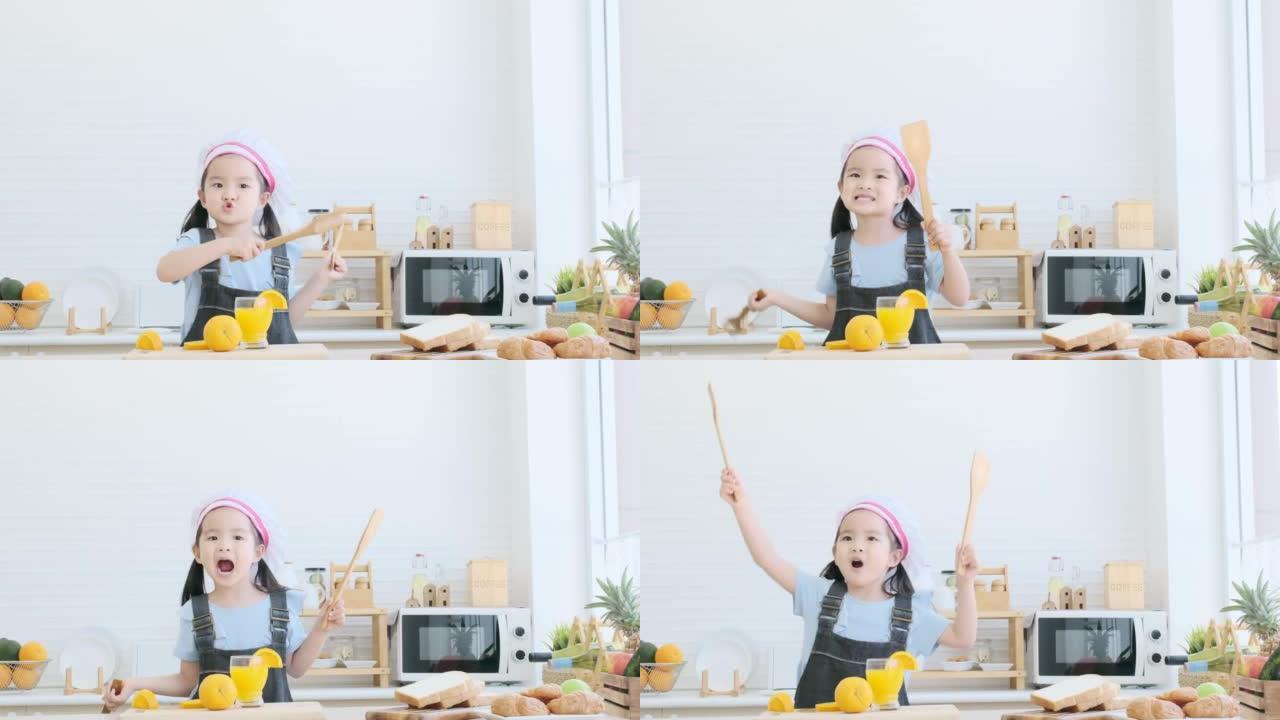 Little girl holding wooden spoons to mix salad and