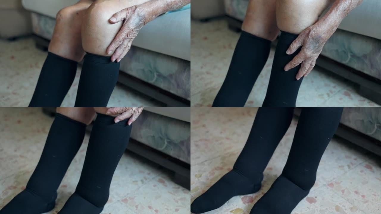 腿部和足部肿胀的高级男子穿着高黑色袜子，以改善血液循环，慢性关节和肌腱炎症，同时坐着或走路。养老金领
