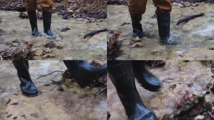 男人橡胶靴河。用冷水洗靴子。