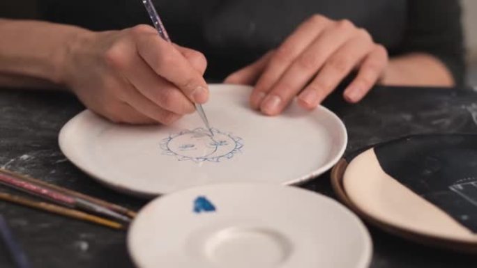 女人用刷子在盘子上画画