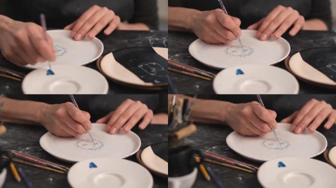 女人用刷子在盘子上画画