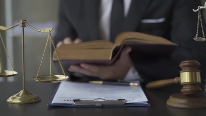 律师在办公室阅读法律书籍。影片以女性正义模型为特色，即道德力量的人格化。桌子上法官的锤子4k