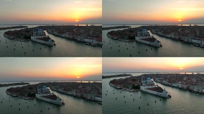 航拍无人机日落景象的圣玛丽亚德拉致敬罗马天主教教堂和小教堂与交通船之间的大运河和朱得卡运河