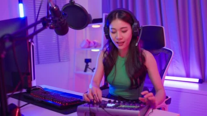 Asian attractive audio DJ woman speaks into microp