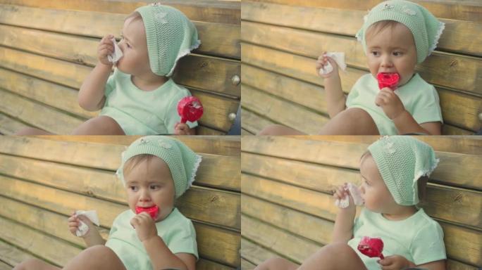 一个2岁的女孩吃冰淇淋，用湿纸巾自己擦脸，特写