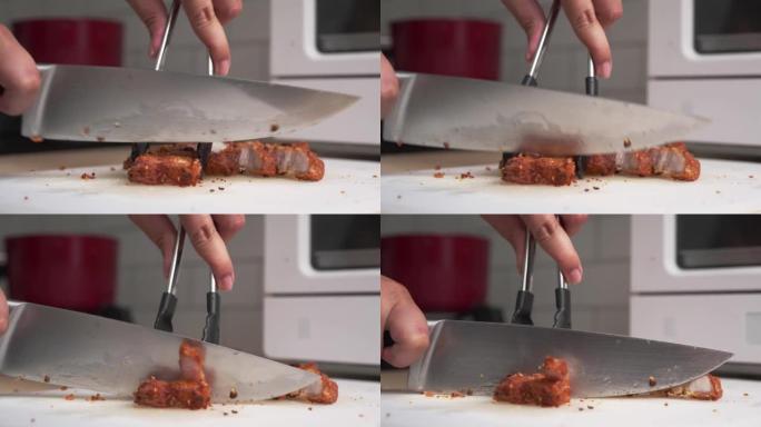 在家用厨房用菜刀在船上手工切割或切碎炸猪肚肉的特写镜头。高胆固醇食物烹饪
