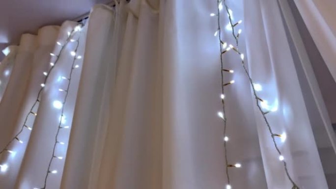 窗帘上有冷光的圣诞花环4K