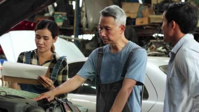 握手和问候。亚洲年轻人顾客在汽车维修服务和汽车商店与车主和机械师交谈