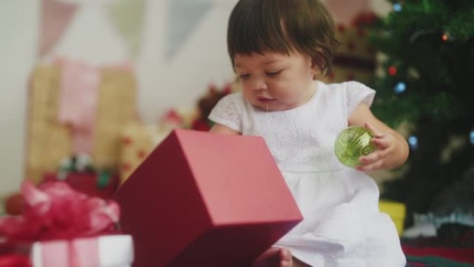 9个月大女婴的幸福，圣诞树前有礼品盒。