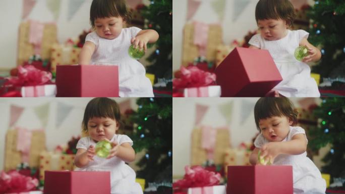9个月大女婴的幸福，圣诞树前有礼品盒。