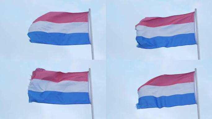 荷兰国旗在蓝天背景下迎风飘扬，特写